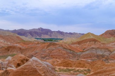 Gökkuşağı Dağı 'nın muhteşem manzarası ve gün batımında mavi gökyüzü arkaplanı. Zhangye Danxia National Geopark, Gansu, Çin. Renkli manzara, gökkuşağı tepeleri, sıra dışı renkli kayalar, kumtaşı erozyonu.