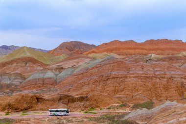 Tek bir turist otobüsü Zhangye Danxia Jeoloji Parkı, Zhangye, Gansu, Çin 'de yola çıkıyor.