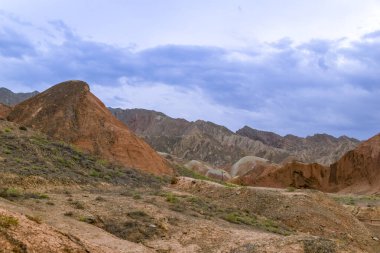 Gökkuşağı Dağı 'nın muhteşem manzarası ve gün batımında mavi gökyüzü arkaplanı. Zhangye Danxia National Geopark, Gansu, Çin. Renkli manzara, gökkuşağı tepeleri, sıra dışı renkli kayalar, kumtaşı erozyonu.