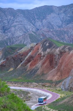 Gökkuşağı Dağı 'nın muhteşem manzarası ve gün batımında mavi gökyüzü arkaplanı. Zhangye Danxia National Geopark, Gansu, Çin. Renkli manzara, gökkuşağı tepeleri, sıra dışı renkli kayalar, kumtaşı erozyonu.