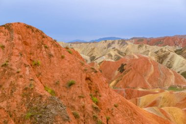 Gökkuşağı Dağı 'nın muhteşem manzarası ve gün batımında mavi gökyüzü arkaplanı. Zhangye Danxia National Geopark, Gansu, Çin. Renkli manzara, gökkuşağı tepeleri, sıra dışı renkli kayalar, kumtaşı erozyonu.