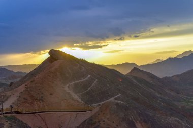Gökkuşağı Dağı 'nın muhteşem manzarası ve gün batımında mavi gökyüzü arkaplanı. Zhangye Danxia National Geopark, Gansu, Çin. Renkli manzara, gökkuşağı tepeleri, sıra dışı renkli kayalar, kumtaşı erozyonu.