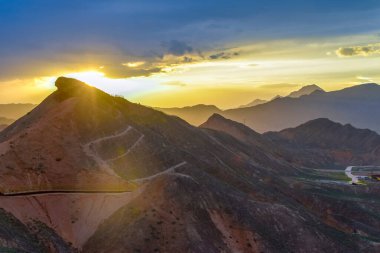 Gökkuşağı Dağı 'nın muhteşem manzarası ve gün batımında mavi gökyüzü arkaplanı. Zhangye Danxia National Geopark, Gansu, Çin. Renkli manzara, gökkuşağı tepeleri, sıra dışı renkli kayalar, kumtaşı erozyonu.