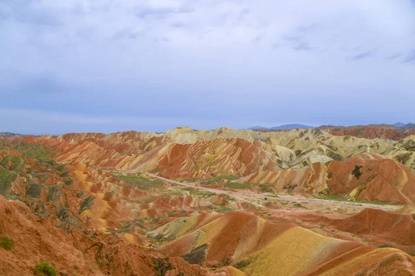 Gökkuşağı Dağı 'nın muhteşem manzarası ve gün batımında mavi gökyüzü arkaplanı. Zhangye Danxia National Geopark, Gansu, Çin. Renkli manzara, gökkuşağı tepeleri, sıra dışı renkli kayalar, kumtaşı erozyonu.