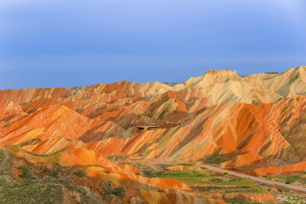 Gökkuşağı Dağı 'nın muhteşem manzarası ve gün batımında mavi gökyüzü arkaplanı. Zhangye Danxia National Geopark, Gansu, Çin. Renkli manzara, gökkuşağı tepeleri, sıra dışı renkli kayalar, kumtaşı erozyonu.