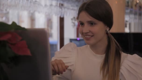 Дівчинка Білій Куртці Ввечері Сидить Столом Барі Ноутбуком Показує Свої — стокове відео