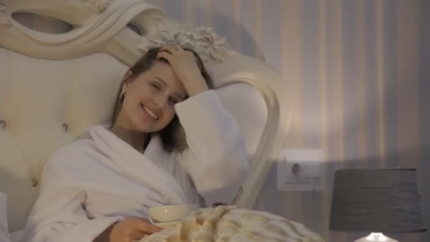 Κορίτσι Σλαβική Εμφάνιση Λευκό Παλτό Κάθεται Στο Κρεβάτι Στο Ξενοδοχείο — Αρχείο Βίντεο