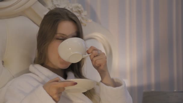 Flicka Slaviska Utseende Vit Rock Sitter Sängen Hotellet Dricka Morgonkaffe — Stockvideo