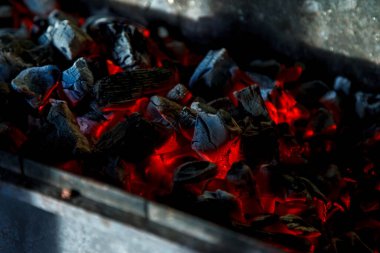 Sıcak kömür. Kömür yanması. Izgarada yanan kızgın kömürlerin yakın çekimi. Kapatın. Yukarıdan bak. Yaratıcı süreç için karanlık bir altyapı. Barbekü işlemi. Ev yemeği.