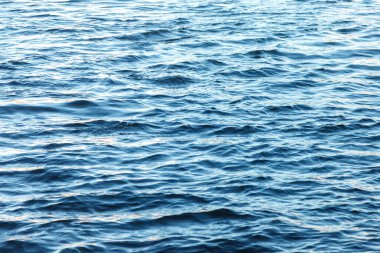 Su yüzeyindeki dalgalar. Dalga deseni. Yüzeyin temiz ya da deniz suyunun görüntüsü. Deniz dalgaları. Deniz ya da okyanus dalgalarının arka planı. Su yüzeyi duvar kağıdı ya da arka plan konsepti. Gürültülü fotoğraf suyu dalgalandırır