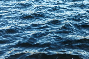 Su yüzeyindeki dalgalar. Dalga deseni. Yüzeyin temiz ya da deniz suyunun görüntüsü. Deniz dalgaları. Deniz ya da okyanus dalgalarının arka planı. Su yüzeyi duvar kağıdı ya da arka plan konsepti. Gürültülü fotoğraf suyu dalgalandırır