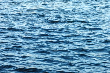 Su yüzeyindeki dalgalar. Dalga deseni. Yüzeyin temiz ya da deniz suyunun görüntüsü. Deniz dalgaları. Deniz ya da okyanus dalgalarının arka planı. Su yüzeyi duvar kağıdı ya da arka plan konsepti. Gürültülü fotoğraf suyu dalgalandırır
