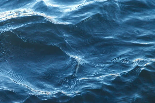 Waves on water surface. Wave pattern. View of surface fresh or sea water. Lapping sea waves. Background of sea or ocean wave. Water surface Wallpaper or background concept. Noise photo ripples water