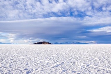 Manzara tuzu bataklığı altıgen tuz oluşumlarıyla geniştir, Salar de Uyuni 'deki dağlar, dokulu bulutlu mavi gökyüzü (Uyuni tuz ovası) gündüz, Bolivya. Güney Amerika Doğası