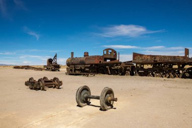 Uyuni paslı tren mezarlığı. Tren mezarlığı. Eski terk edilmiş trenler ve tekerlekler çölün ortasında kumlara kurulur. Uyuni 'deki manzara manzarası. Bolivya 'da Turist Çekimi. Güney Amerika Doğası