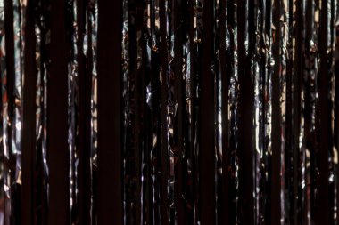 Süslü püslü bir arka plan. Altın bilezikler takılıyor. Dikey beyaz ve siyah çizgiler. Tatil ışıkları, çelenkler. Parti, kutlama, soyut ve şenlikli arka plan dokuları. Folyo şeritleri, dekorasyon