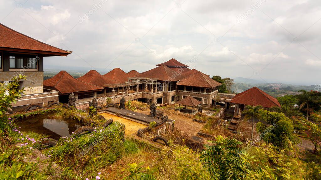 Abandoned hotel. Grass through stone. Aancient face. Mysterious hotel without visitors or tourists. View of five-star hotel and tropical island. Trip to Bedugul, Indonesia, Bali island