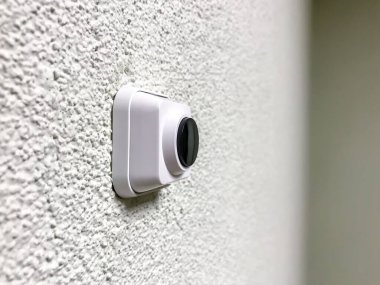 Beyaz desenli duvarda siyah düğmeli plastik kapı zili. Alçılı duvardaki plastik düğme. Basmak için yuvarlak düğme. Yazarın yeri. Bir yazı veya logo için geniş arkaplan alanı