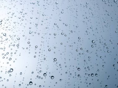Arka plandaki su damlaları. Doğal yağmur damlaları. Pencere camlarına yağmur damlası. Camdaki yağmur damlalarının soyut bir görüntüsü. Soyut yağmur damlası cam üzerine yağar. Bir yazı veya logo için yer