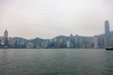 Hong Kong, Şubat 2014: Megalopolis 'teki Hong Kong adasında rıhtım. Manzaralı ve manzaralı büyük Asya şehrinin turistik beldesi. Sisli toprak setinin kentsel manzarası.
