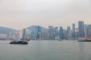 Hong Kong, Şubat 2014: Megalopolis 'teki Hong Kong adasında rıhtım. Manzaralı ve manzaralı büyük Asya şehrinin turistik beldesi. Sisli toprak setinin kentsel manzarası.