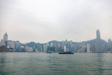 Hong Kong, Şubat 2014: Megalopolis 'teki Hong Kong adasında rıhtım. Manzaralı ve manzaralı büyük Asya şehrinin turistik beldesi. Sisli toprak setinin kentsel manzarası.
