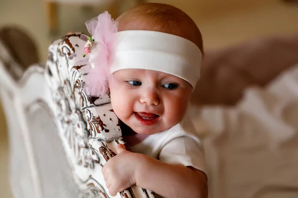 可爱的蓝眼睛6个月大的小女孩 头戴白色的头巾 头戴复古床 漂亮的金发美女迷人的孩子在特写中表现出感情 健康儿童和养育子女的概念 — 图库照片