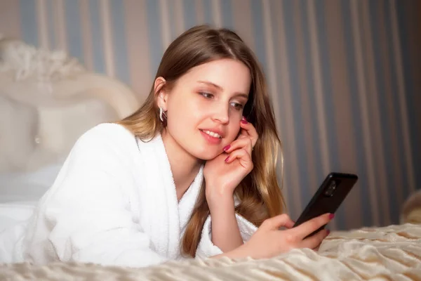Girl Slavic Appearance White Coat Phone Bed Hotel Room Pretty — Stock Photo, Image