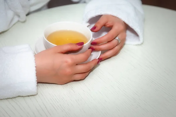 Tazza Nelle Mani Delle Donne Ragazza Cappotto Bianco Tavola Giovane — Foto Stock