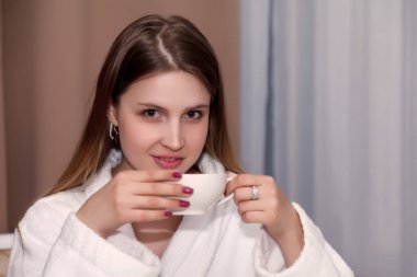 Beyaz Kupa 'lı Slav kız masada oturuyor. Kadın, aktörün duygularını alır. Genç çekici kadın otel odasında oturuyor ve kahve ya da çay içiyor. Rahatla konsept