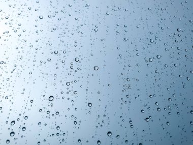 Arka plandaki su damlaları. Doğal yağmur damlaları. Pencere camlarına yağmur damlası. Camdaki yağmur damlalarının soyut bir görüntüsü. Soyut yağmur damlası cam üzerine yağar. Bir yazı veya logo için yer