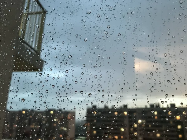 背景水滴 窗玻璃上的雨滴 天然的雨滴模式 玻璃上的雨滴的抽象镜头 窗外的夜城和阳台 有选择的重点 文字或标志的空间 — 图库照片