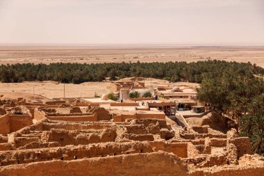 Sahra Çölü 'ndeki Chebika vahasının manzarası. Yerleşim ve avuç içini harap eder. Kuzey Afrika 'daki manzaralı dağ vahası. Yaya olarak Jebel El Negueba 'da bulunuyor. Güneşli bir öğleden sonra Atlas Dağları. Tozeur, Tunus