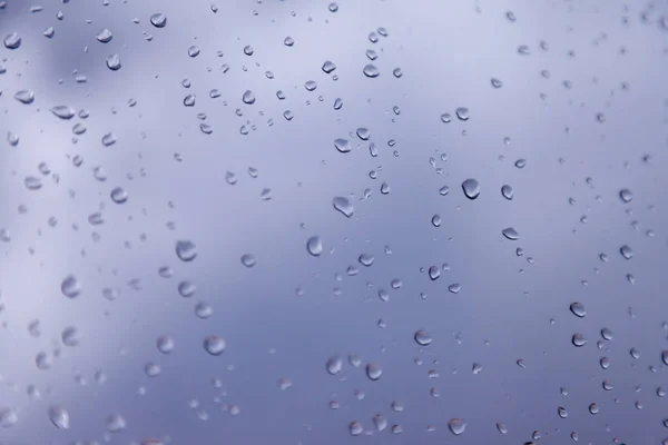 Background water drops. Raindrops on window panes. Natural pattern of rain drops. Abstract shot of raindrops on glass. Abstract falling rain drop of rain on glass. Place for an inscription or logo