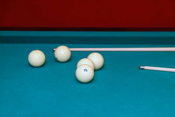 Billiard balls and cue on pool table. Russian billiards. Close-up of items for the game. Background space. Concept of sports games. Place for an inscription or logo