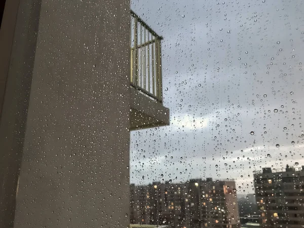 背景水滴 窗玻璃上的雨滴 天然的雨滴模式 玻璃上的雨滴的抽象镜头 窗外的夜城和阳台 有选择的重点 文字或标志的空间 — 图库照片