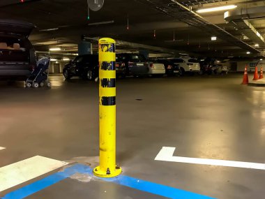 Underground garage or modern parking lot with large number of cars. Underground Parking of shopping center or garage interior with restriction posts, color-coded stripes on concrete floor clipart