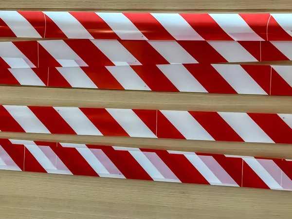 Red and white lines of barrier tape on wall. Pass forbidden, security tape with stripes. Signal tape that prohibits entry to object. Warning tape. Danger unsafe area do not enter. Concept of no entry