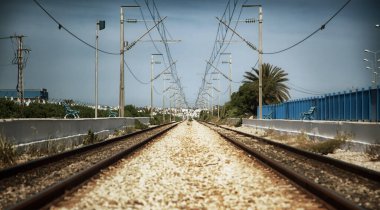 Tunus, Kuzey Afrika 'daki tren istasyonunda eski bir demiryolu. Demiryolu platformu, raylar ve elektrik kabloları. Giden yolun peyzaj görüntüsü