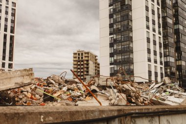 Yıkık bina enkazı yeni ve bitmemiş konut binalarının arka planına karşı. Metropolis 'te konut yenileme kavramı. Telif hakkı alanı olan arkaplan oluşturuluyor
