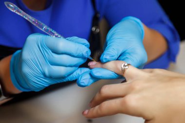 Manikür ustası kuaförde genç ve güzel bir kadın tırnaklıyor. Dahili salondaki müşteri hizmetleri inanılmaz bir imaj yaratıyor. Manikür yaratma sihirbazı. Güzellik tatmini kavramı