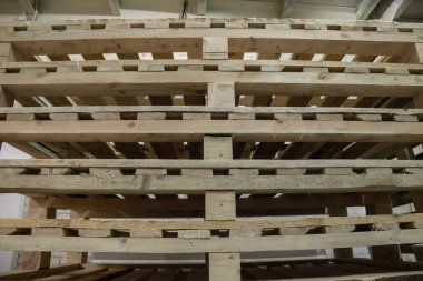 Depoda kullanılmış ahşap paletler var. Yığınla Avrupa tipi kargo paleti. Ahşap paletlerin arka planı. Mal depolama ve depolama kavramı