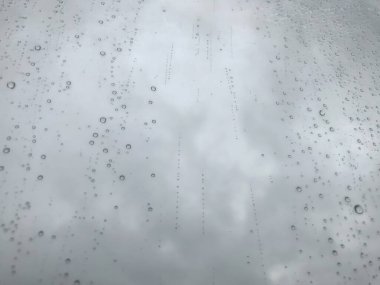 Arka plandaki su damlaları. Doğal yağmur damlaları. Pencere camlarına yağmur damlası. Camdaki yağmur damlalarının soyut bir görüntüsü. Soyut yağmur damlası cam üzerine yağar. Bir yazı veya logo için yer
