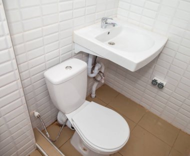 Banyodaki beyaz lavabo ve tuvalet fayans duvarına karşı. Küçük banyo alanları için tasarım arka planı. Yukarıdan bak. Metin için telif hakkı alanı