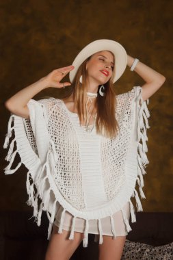 Şirin, mutlu bir şekilde giyinmiş, sarı saçlı, altın sarısı şapkalı, mutlu ve mutlu bir şekilde kameraya bakıyor. Duygusal portre kavramı. Telif Hakkı Boşluğu