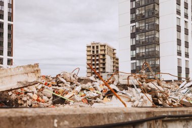 Yıkık bina enkazı yeni ve bitmemiş konut binalarının arka planına karşı. Metropolis 'te konut yenileme kavramı. Telif hakkı alanı olan arkaplan oluşturuluyor