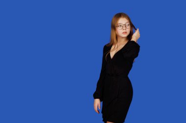 Gözlük takan 13 yaşında duygusal bir genç kız dikkatlice uzaklaşıyor, mavi arka planda soyutlanıyor. Siyah elbiseli beyaz çocuk etiketini ya da logonuzu açıyor. Boşluğu kopyala