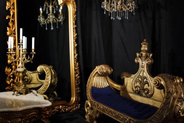 Lüks, klasik ev yapımı, siyah ve altın kaplamalı. Ayna, kanepe ve şamdanlı oturma odası. Zarif mobilyaları olan antika bir arka plan. Bağbozumu kavramı. Site veya afiş için telif hakkı alanı