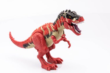 Beyaz arkaplanda izole edilmiş plastik bir tyranosaurus renkli heykelciğin yakın çekimi