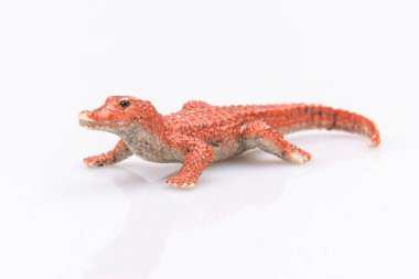 Beyaz arka planda izole edilmiş turuncu plastik bir timsahın yakın çekimi